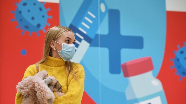Девушка ожидает своей очереди в пункте вакцинации от коронавируса Covid-19 в торгово-развлекательном центре Аура в Новосибирске
