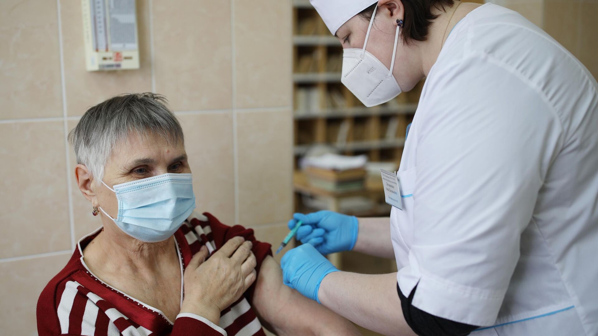 Медицинский сотрудник делает женщине прививку российским препаратом от коронавирусной инфекции ЭпиВакКорона - РИА Новости, 1920, 13.11.2021