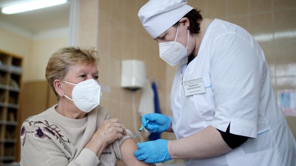 Медицинский сотрудник делает женщине прививку российским препаратом от коронавирусной инфекции Гам-Ковид-Вак