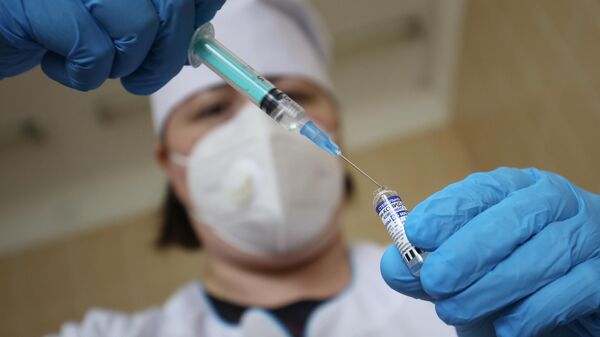 Медицинский сотрудник набирает в шприц препарат от коронавирусной инфекции Гам-Ковид-Вак (Спутник V) 