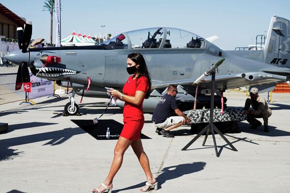 Девушка проходит мимо штурмовика Beechcraft AT-6 Wolverine на международном авиасалоне Dubai Airshow 2021
