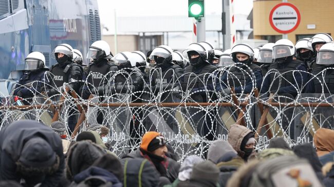 Сотрудники польской полиции и мигранты на белорусско-польской границе в районе пограничного перехода Кузница