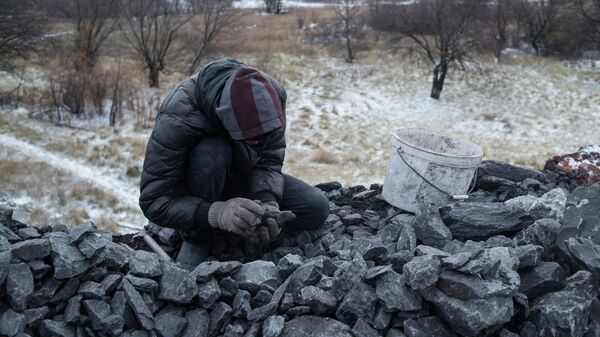 Мужчина собирает уголь из отвала шахты