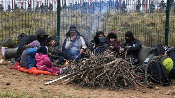 Беженцы с Ближнего Востока жгут костер у пункта пропуска Брузги на белорусско-польской границе