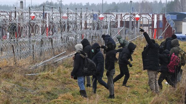 Беженцы у проволочных заграждений на белорусско-польской границе в районе погранперехода Брузги - Кузница