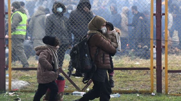 Беженка с детьми у проволочных заграждений на белорусско-польской границе