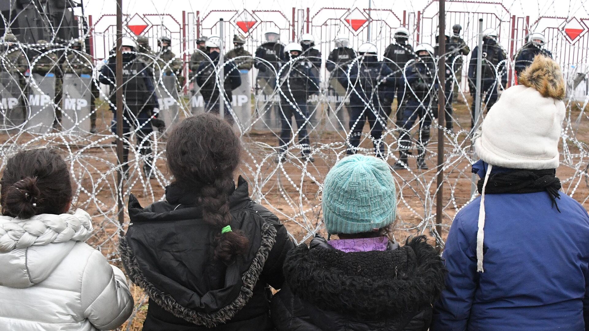 Дети из лагеря нелегальных мигрантов и польские военные у лагеря нелегальных мигрантов на белорусско-польской границе1