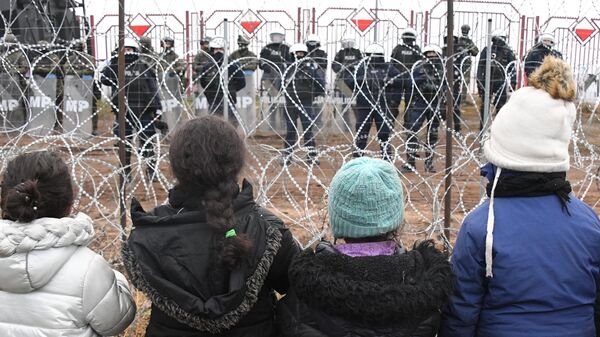 Дети из лагеря нелегальных мигрантов и польские военные у лагеря нелегальных мигрантов на белорусско-польской границе