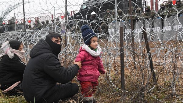 Люди из лагеря нелегальных мигрантов и польские военные у лагеря нелегальных мигрантов на белорусско-польской границе