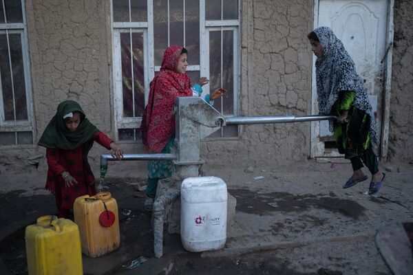 Девочки набирают воду в лагере для внутренне перемещенных лиц в Кабуле, Афганистан