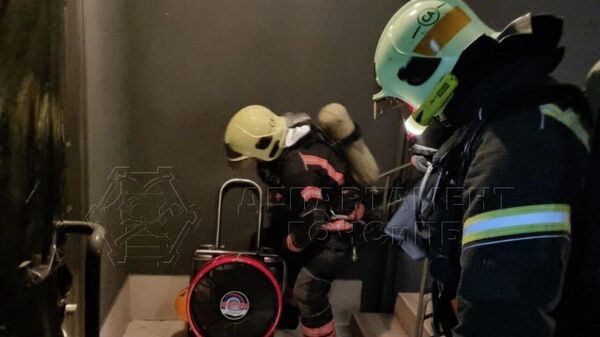 Спасатели у квартиры в жилом доме на улице Ратной в Москве, где произошел пожар