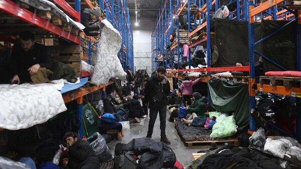 Беженцы с Ближнего Востока в центре временного содержания мигрантов, оборудованном в логистическом центре в пункте пропуска Брузги