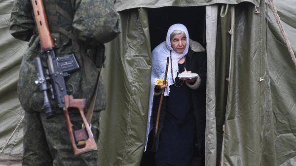 Женщина выходит из палатки с пунктом питания на белорусско-польской границе