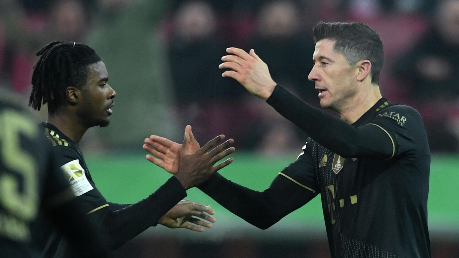 Bayern Munich's Polish forward Robert Lewandowski celebrates scoring the 2-1 with his teammate Bayern Munich's English defender Omar Richards (L) during the German first division Bundesliga football match FC Augsburg v FC Bayern Munich in Augsburg, southern Germany, on November 19, 2021. (Photo by Christof STACHE / AFP) / DFL REGULATIONS PROHIBIT ANY USE OF PHOTOGRAPHS AS IMAGE SEQUENCES AND/OR QUASI-VIDEO / “The erroneous mention[s] appearing in the metadata of this photo by Christof STACHE has been modified in AFP systems in the following manner: [Bayern Munich's Polish forward Robert Lewandowski ] instead of [Augsburg's German midfielder Andre Hahn ]. Please immediately remove the erroneous mention[s] from all your online services and delete it (them) from your servers. If you have been authorized by AFP to distribute it (them) to third parties, please ensure that the same actions are carried out by them. Failure to promptly comply with these instructions will entail liability on your part for any continued or post notification usage. Therefore we thank you very much for all your attention and prompt action. We are sorry for the inconvenience this notification may cause and remain at your disposal for any further information you may require.” - РИА Новости, 1920, 20.11.2021