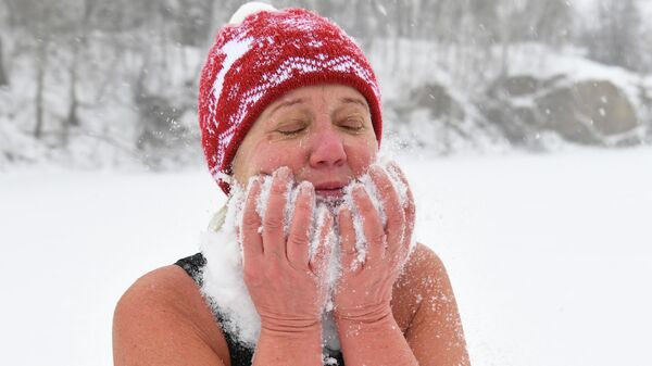 Женщина обтирается снегом