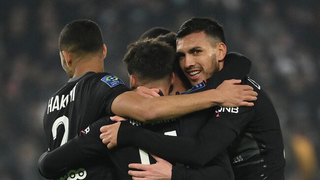 Paris Saint-Germain's Argentinian midfielder Leandro Paredes (R) looks on as he congratulates Paris Saint-Germain's Argentinian forward Lionel Messi (unseen) after scoring a goal during the French L1 football match between Paris-Saint Germain (PSG) and FC Nantes at The Parc des Princes Stadium in Paris on November 20, 2021. (Photo by FRANCK FIFE / AFP)