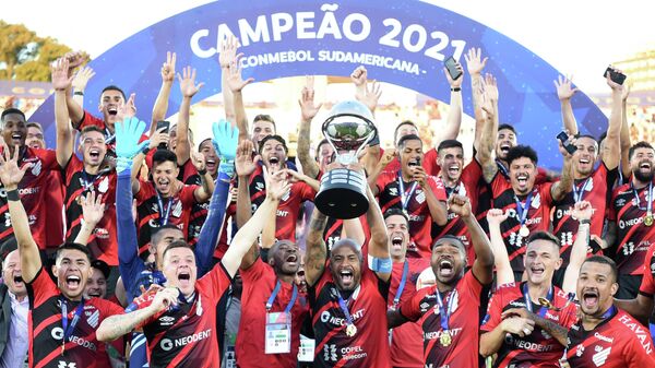Athletico Paranaense's Thiago Heleno (C) raises the trophy of the Copa Sudamericana football tournament next to teammates after defeating Red Bull Bragantino in the all-Brazilian final match, at the Centenario Stadium in Montevideo on November 20, 2021. (Photo by EITAN ABRAMOVICH / AFP)