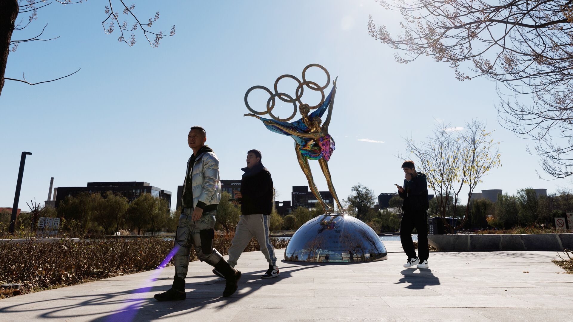 Люди проходя мимо скульптуры в виде олимпийских колец в Пекине - РИА Новости, 1920, 21.11.2021