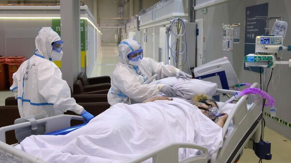 Медицинские сотрудники и пациент с COVID-19 в резервном госпитале на ВДНХ в Москве