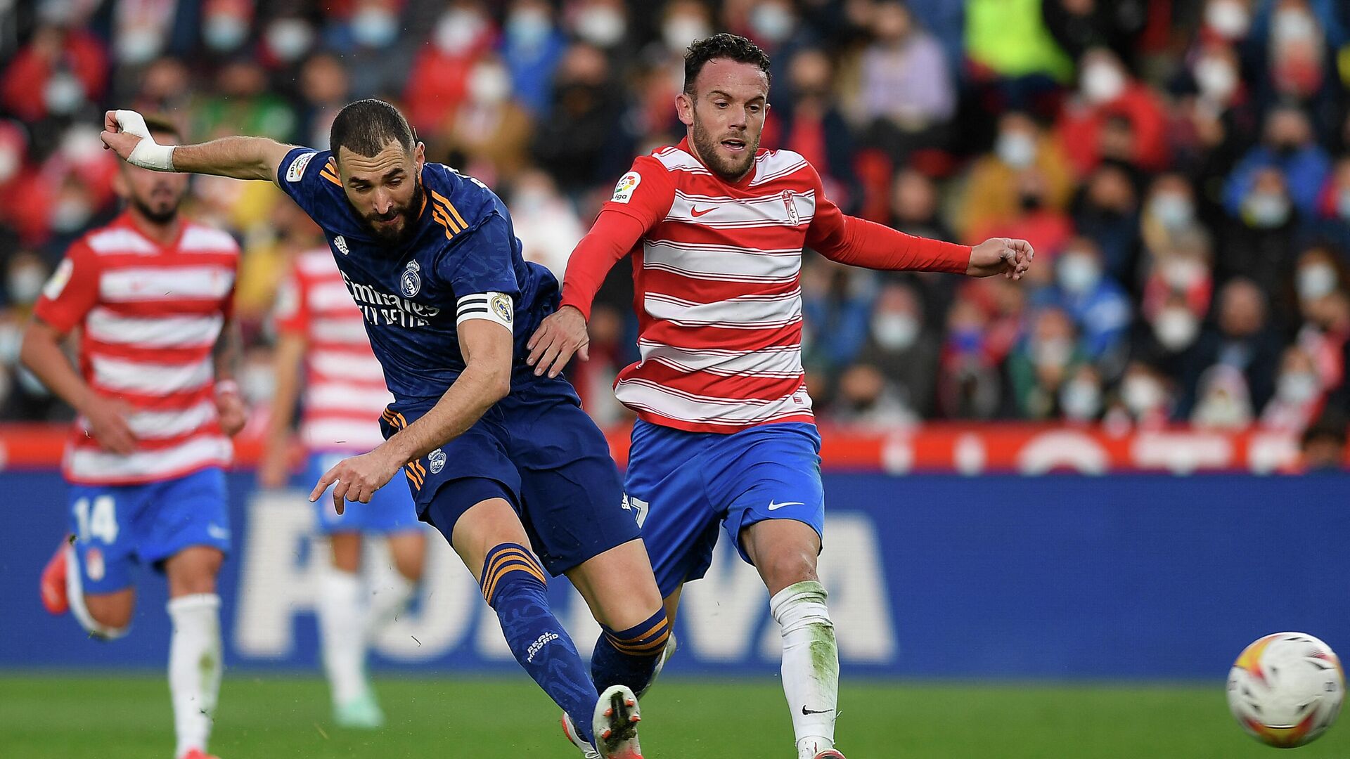 Real Madrid's French forward Karim Benzema (L) fights for the ball with Granada's Spanish defender Quini during the Spanish League football match between Granada FC and Real Madrid CF at Nuevo Los Carmenes stadium in Granada on November 21, 2021. (Photo by JORGE GUERRERO / AFP) - РИА Новости, 1920, 21.11.2021