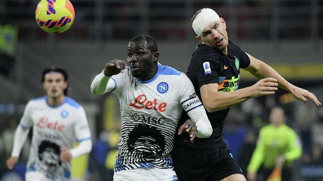 Inter Milan's Bosnian forward Edin Dzeko (R) heads the ball next to Napoli's Senegalese defender Kalidou Koulibaly (C) during the Italian Serie A football match between Inter and Napoli, at the San Siro Stadium in Milan, on November 21, 2021. (Photo by Filippo MONTEFORTE / AFP)