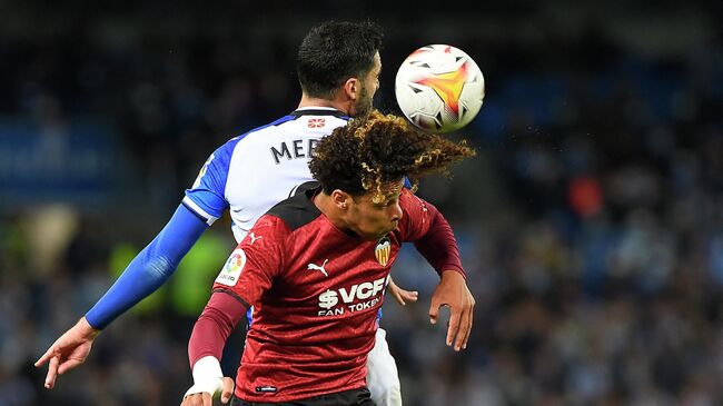 Real Sociedad's Spanish midfielder Mikel Merino (L) fights for the ball with Valencia's French midfielder Koba Koindredi during the Spanish League football match between Real Sociedad and Valencia CF at the Anoeta stadium in San Sebastian on November 21, 2021. (Photo by ANDER GILLENEA / AFP)