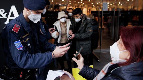 Полицейские проверяют QR-коды о вакцинацию от коронавируса у покупателей у входа в магазин в Вене