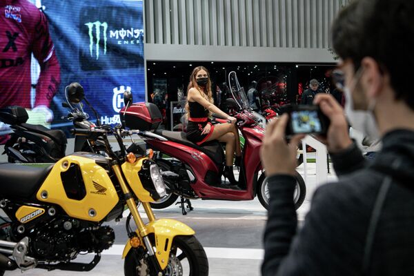 Мужчина фотографирует мотоцикл Honda на 78-q Международной выставке велосипедов и мотоциклов в Милане