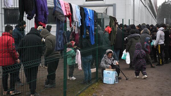 Беженцы с Ближнего Востока в центре временного содержания мигрантов, оборудованном в логистическом центре в пункте пропуска Брузги