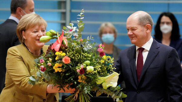 Канцлер Германии Ангела Меркель получает букет цветов от Олафа Шольца перед заседанием кабинета министров в Берлине