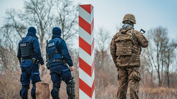 Сотрудники полиции Польши и польский военнослужащий на границе с Белоруссией