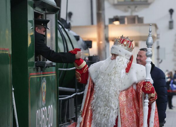 Дед Мороз пожимает руку машинисту поезда, подаренного РЖД к приближающемуся Новому году и Рождеству, на Казанском вокзале в Москве