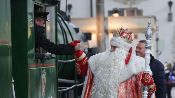 Дед Мороз пожимает руку машинисту поезда, подаренного РЖД к приближающемуся Новому году и Рождеству, на Казанском вокзале в Москве