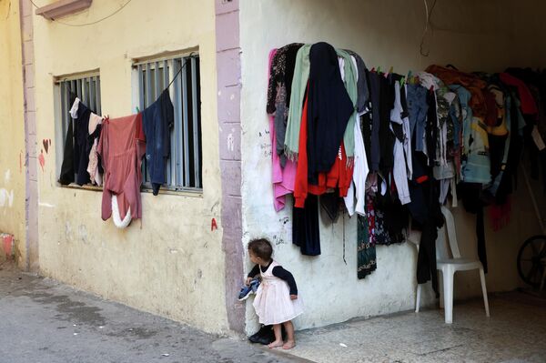 Ребенок выглядывает из-за угла дома в разрушенном районе Карантина в Бейруте 