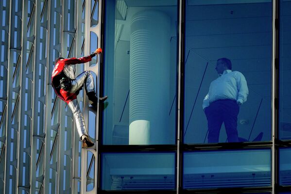 Французский покоритель небоскребов Ален Робер забирается на строительный комплекс Skyper во Франкфурте, Германия 