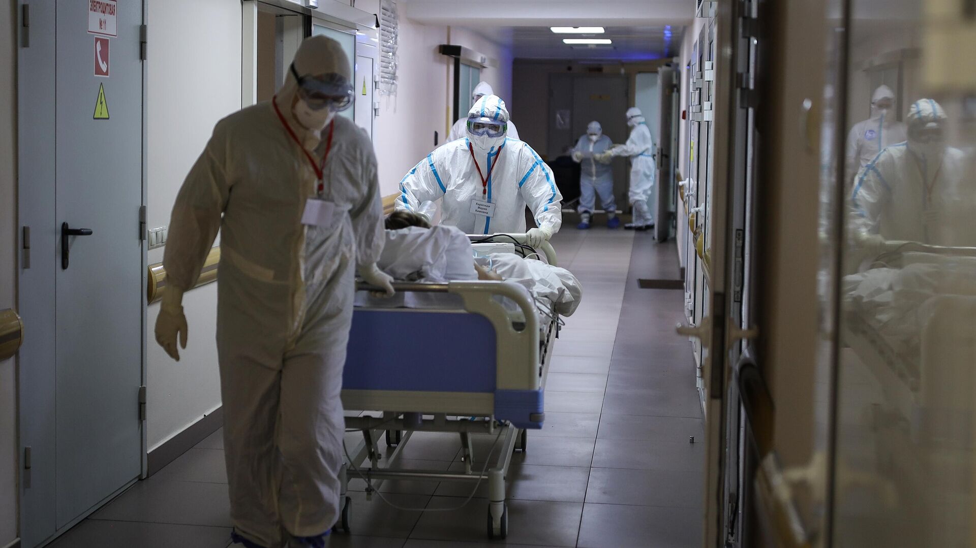Медицинские работники везут пациента на носилках по коридору COVID-госпиталя - РИА Новости, 1920, 22.12.2021
