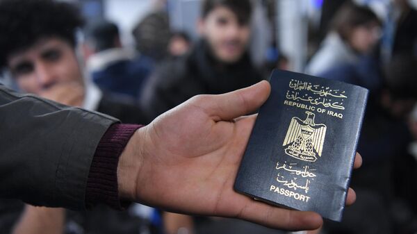 Иракский паспорт в руке одного из беженцев, ожидающих в международном аэропорту Минска вывозных рейсов авиакомпании Iraqi Airways