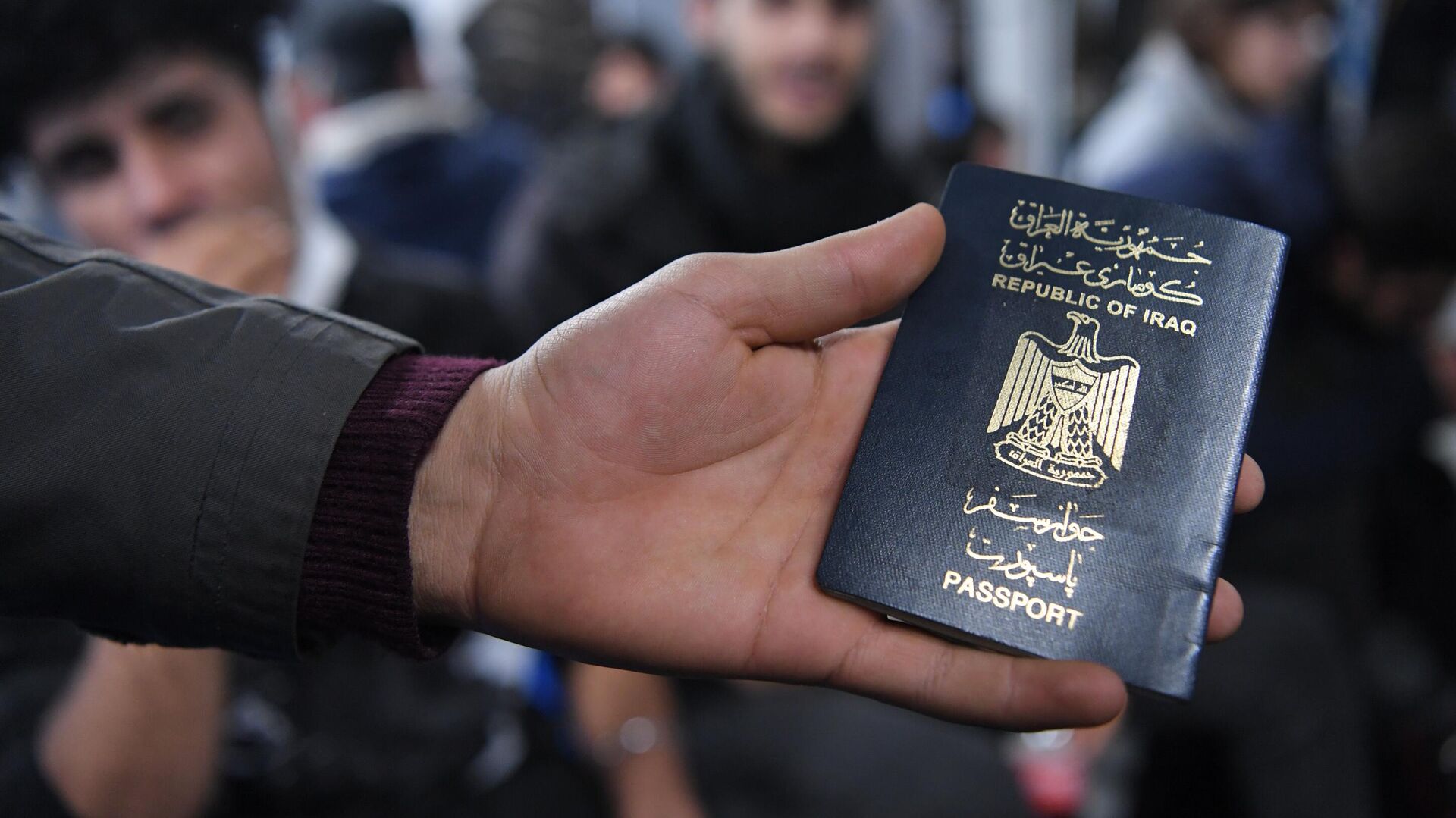 Иракский паспорт в руке одного из беженцев, ожидающих в международном аэропорту Минска вывозных рейсов авиакомпании Iraqi Airways - РИА Новости, 1920, 04.12.2021