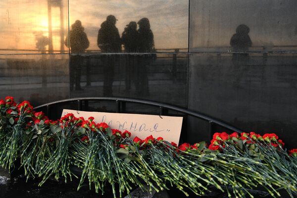 Цветы в память о погибших на шахте Листвяжная у мемориала погибшим шахтерам Кузбасса в Кемерове