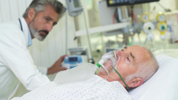 Человек в кислородной маске на больничной койке