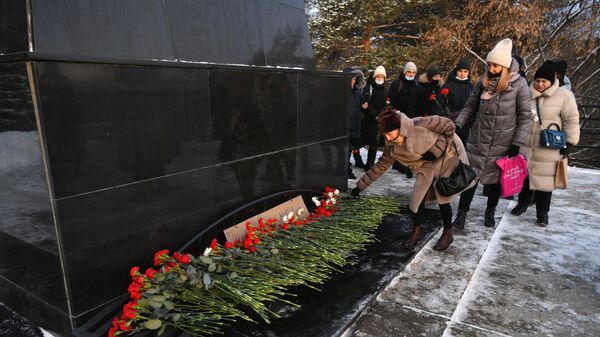 Местные жители возлагают цветы в память о погибших на шахте Листвяжная к мемориалу Память шахтерам Кузбасса в Кемерове1