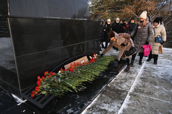 Местные жители возлагают цветы в память о погибших на шахте Листвяжная к мемориалу Память шахтерам Кузбасса в Кемерове