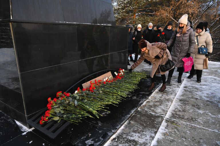 Местные жители возлагают цветы в память о погибших на шахте Листвяжная к мемориалу Память шахтерам Кузбасса в Кемерове