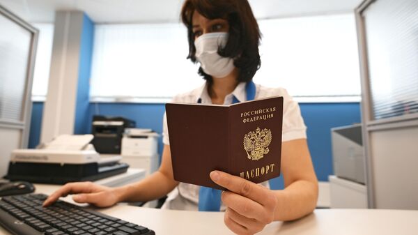 Сотрудник ПФР держит в руках паспорт РФ