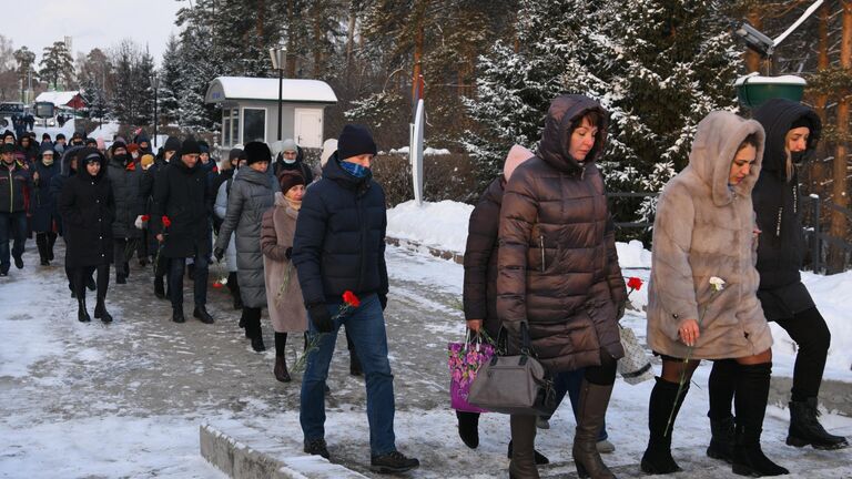 Местные жители несут цветы в память о погибших на шахте Листвяжная к мемориалу Память шахтерам Кузбасса в Кемерове