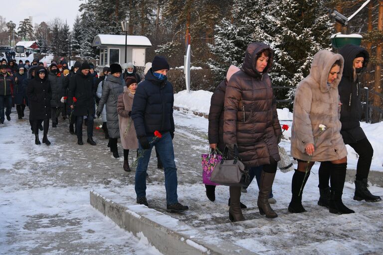 Местные жители несут цветы в память о погибших на шахте Листвяжная к мемориалу Память шахтерам Кузбасса в Кемерове