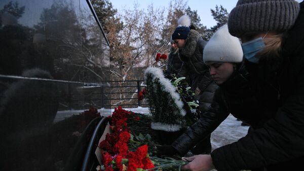 Местные жители возлагают цветы в память о погибших на шахте Листвяжная к мемориалу Память шахтерам Кузбасса в Кемерове3