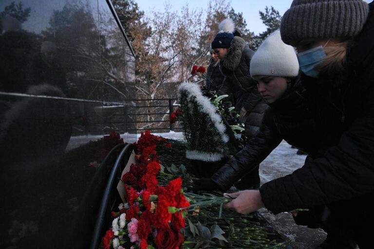 Местные жители возлагают цветы в память о погибших на шахте Листвяжная к мемориалу Память шахтерам Кузбасса в Кемерове