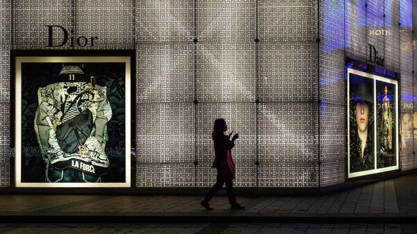 Женщина проходит мимо магазина Dior в Макао, Китай