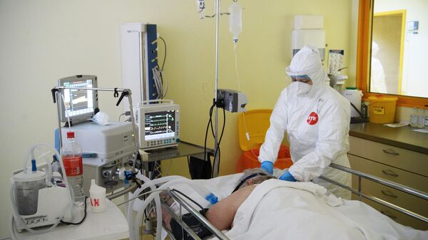 Медицинский работник и пациент c COVID-19 в отделении реанимации и интенсивной терапии в центральной клинической больнице РЖД-Медицина в Москве